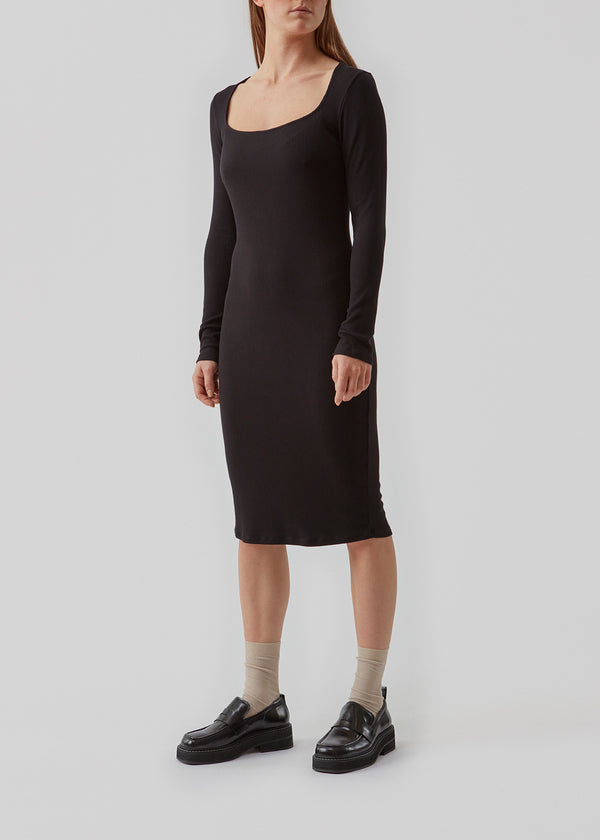 Tight fitting dress with long sleeves and a square neckline. Oxy dress hugs the body and is medi length.