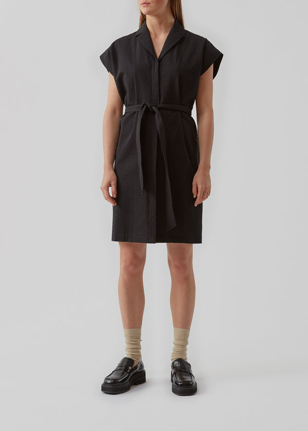 Panne dress in Black is a cotton dress with a beautiful silhouette. The dress features a nice collar, tieband and a sleeveless design with wide shoulders. The model is 173 cm and wears a size S/36