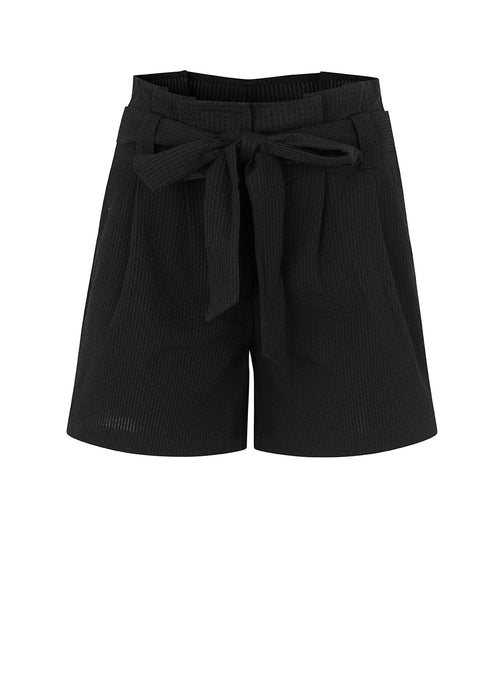 Panne shorts in Black are made from a structured cotton quality. These shorts have a casual, high-waisted silhouette detailed with a belt at the waist. The model is 173 cm and wears a size S/36