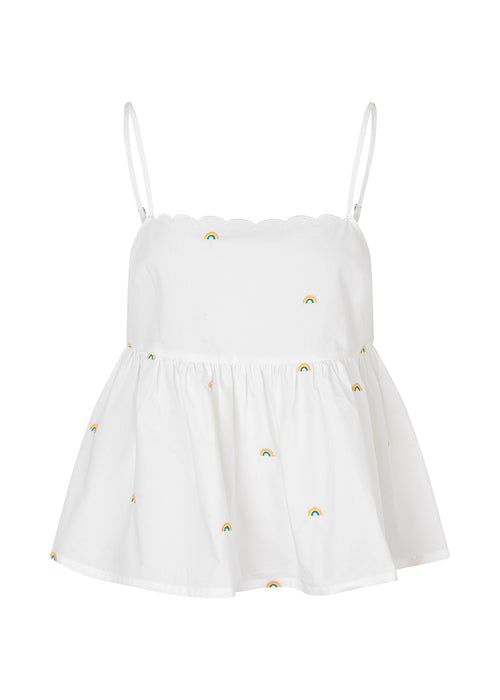 Top in light and airy organic cotton. PernilleMD strap top has adjustable spaghetti straps, scalloped trim at the top, and embroidered rainbows. The top is fitted at the top and flared peplum.