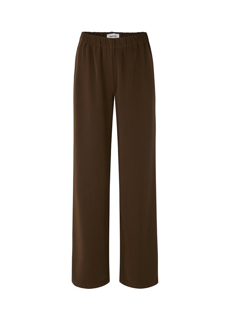 Pants in dark brown in a simple design with wide legs. Perry pants have pockets at side seam and an elasticated waistline for a comfortable fit. The model is 173 cm and wears a size S/36