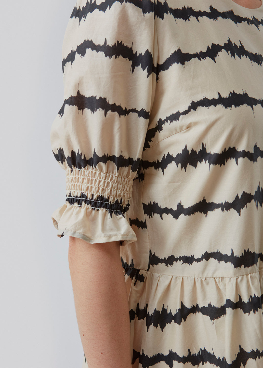 Poem print top features a voluminous fit with short puff sleeves with a smock detail. The tie dye print is made from a responsible cotton. The top has a small button closure on the back. The model is 173 cm and wears a size S/36
