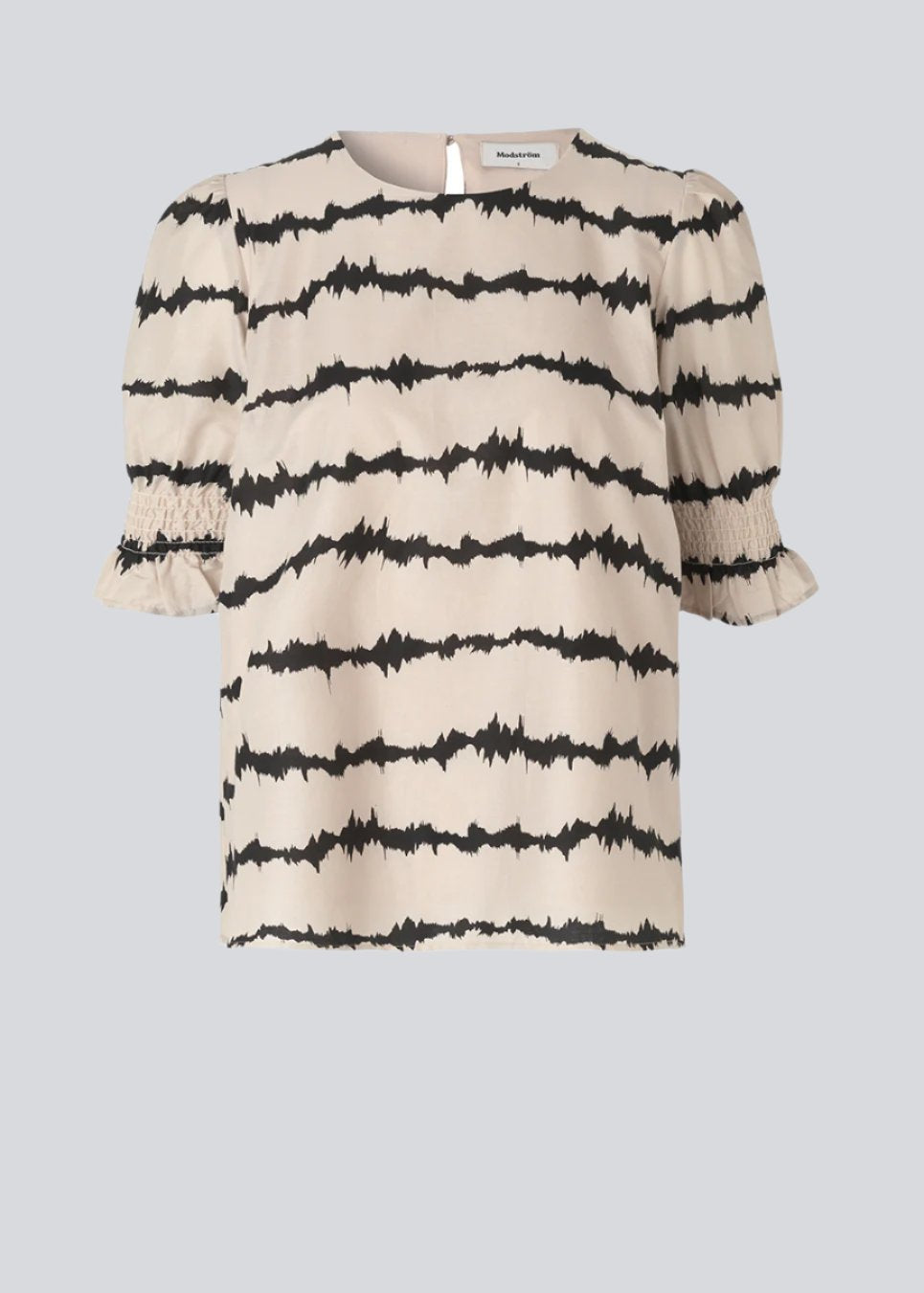 Poem print top features a voluminous fit with short puff sleeves with a smock detail. The tie dye print is made from a responsible cotton. The top has a small button closure on the back. The model is 173 cm and wears a size S/36