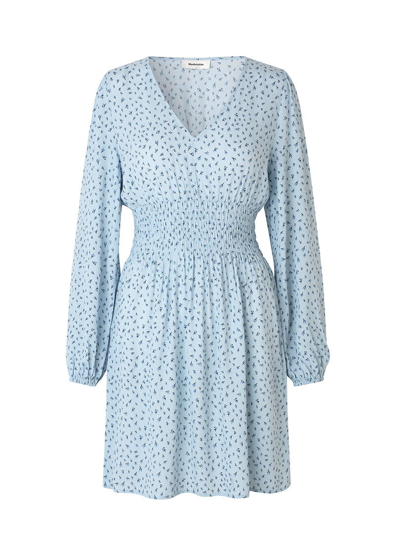 Feminine dress with a flattering smock at the waist. Porscha print dress features a v-neckline and long balloon sleeves with elastics. The material is an EcoVero viscose. The model is 173 cm and wears a size S/36