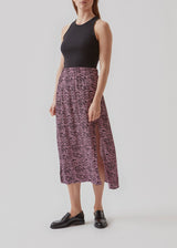 Mid-length skirt in purple with a high slit in front. RaidaMD print skirt is designed with an elasticated waist and a relaxed silhouette. The model is 173 cm and wears a size S/36