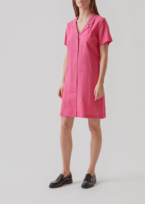 Mid-length dress with short sleeves, collar, and v-neckline. RayaMD dress buttons at the front. The tie belt at the waist adds shape to the design. The model is 173 cm and wears a size S/36