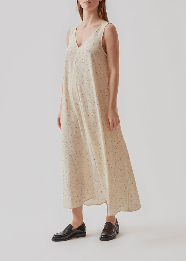 Long, sleeveless dress with wide straps and a deep v-shaped neckline on front and back. The fit is voluminous and easy to layer. The model is 173 cm and wears a size S/36