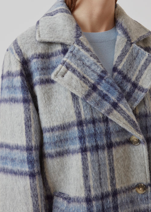 Coat in a soft, checked wool material with a relaxed fit and long, voluminous sleeves. In the color Blue Pearl Check. SallieMD check coat is calf-length, and has a collar and notch lapels with buttons down the front. Side pockets and single back vent. Lined.
