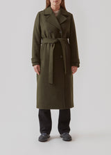 Classic, double-breasted wool coat in army green with collar and notch lapels. ShayMD coat has a wide tiebelt at waist, shoulder straps, wide cuffs and open yoke. With lining and single back vent.