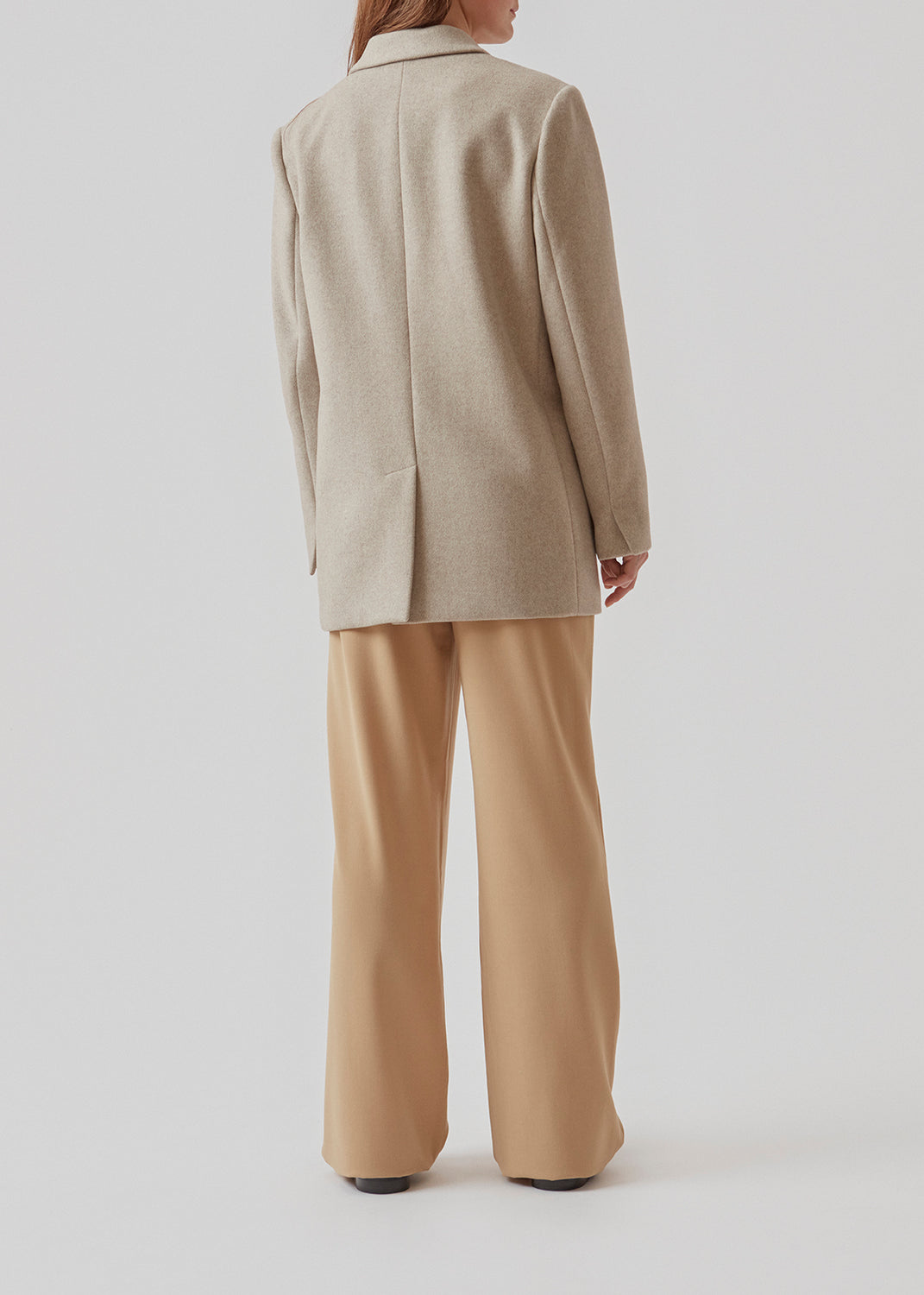 Blazer in light grey with an oversized silhouette in a wool weave. SonnyMD jacket has a collar and notch lapels with two buttons in front and flap front pockets. Slit at sleeves and vent in back. Lined.
