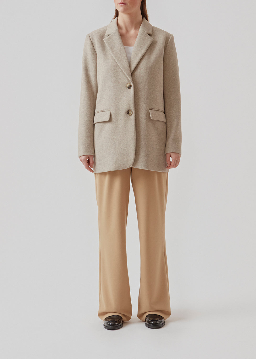 Blazer in light grey with an oversized silhouette in a wool weave. SonnyMD jacket has a collar and notch lapels with two buttons in front and flap front pockets. Slit at sleeves and vent in back. Lined.