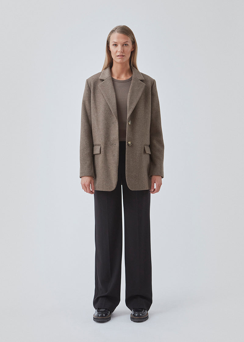 Blazer in brown with an oversized silhouette in a wool weave. SonnyMD jacket has a collar and notch lapels with two buttons in front and flap front pockets. Slit at sleeves and vent in back. Lined.