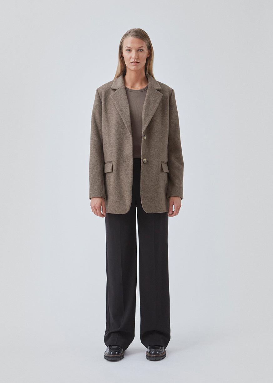 Blazer in brown with an oversized silhouette in a wool weave. SonnyMD jacket has a collar and notch lapels with two buttons in front and flap front pockets. Slit at sleeves and vent in back. Lined.