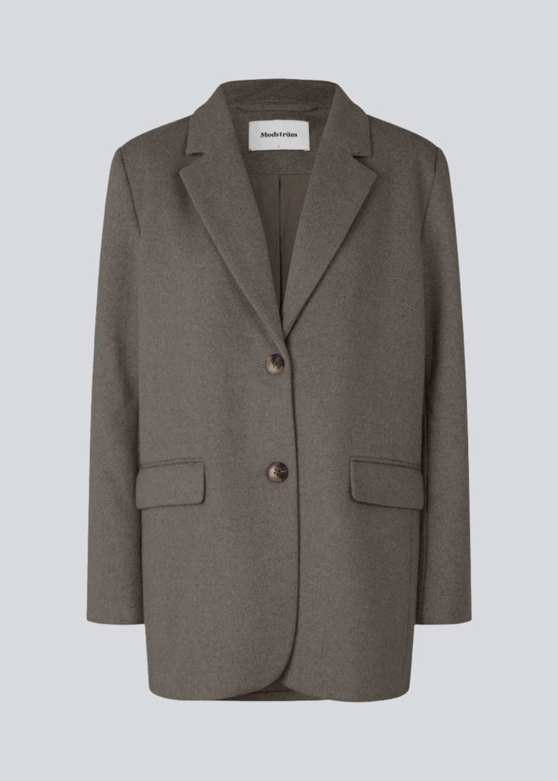 Blazer in brown with an oversized silhouette in a wool weave. SonnyMD jacket has a collar and notch lapels with two buttons in front and flap front pockets. Slit at sleeves and vent in back. Lined.