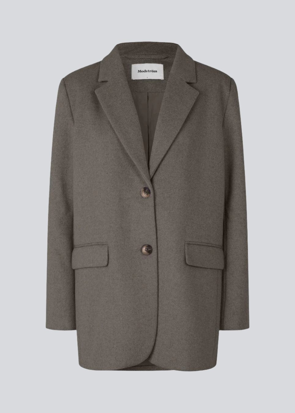 Blazer in brown with an oversized silhouette in a wool weave. SonnyMD jacket has a collar and notch lapels with two buttons in front and flap front pockets. Slit at sleeves and vent in back. Lined.