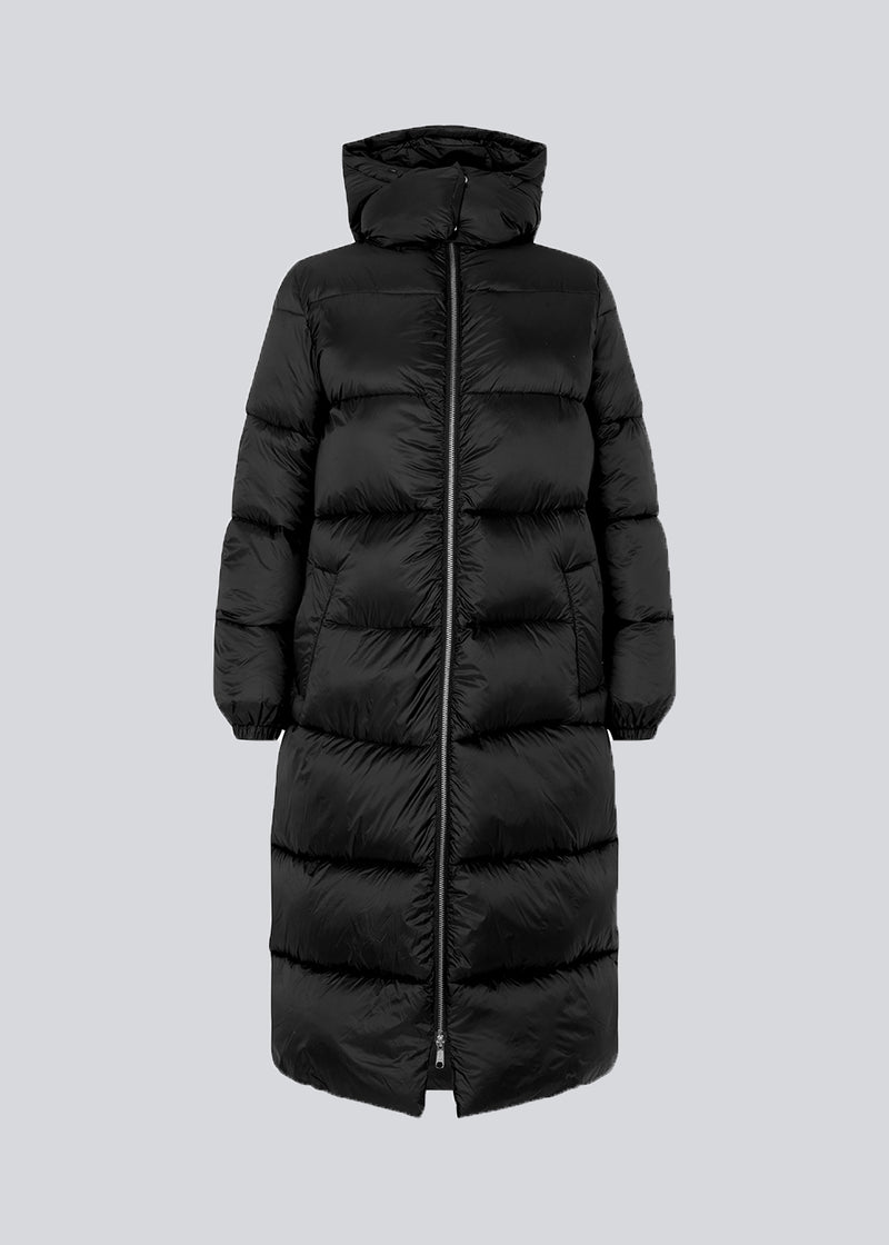 Knee-length coat in black in padded nylon. StellaMD long coat has a relaxed shape with long sleeves, hood and high-standing collar. Two-way zipper, adjustable hood and discreet side pockets.
