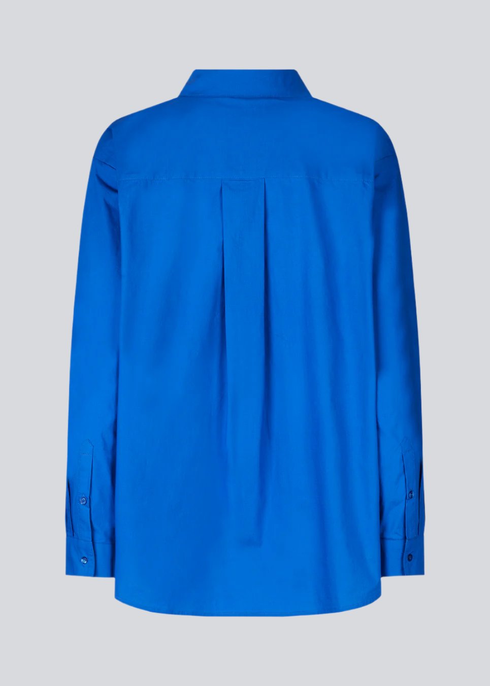 Airy shirt in blue in organic cotton poplin. TapirMD shirt has a collar and buttons in front, with an open chest pocket. Dropped shoulders and long sleeves with cuff and button. Embroidered logo in front.