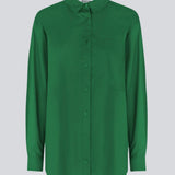 Airy shirt in green organic cotton poplin. TapirMD shirt has a collar and buttons in front, with an open chest pocket. Dropped shoulders and long sleeves with cuff and button. Embroidered logo in front.