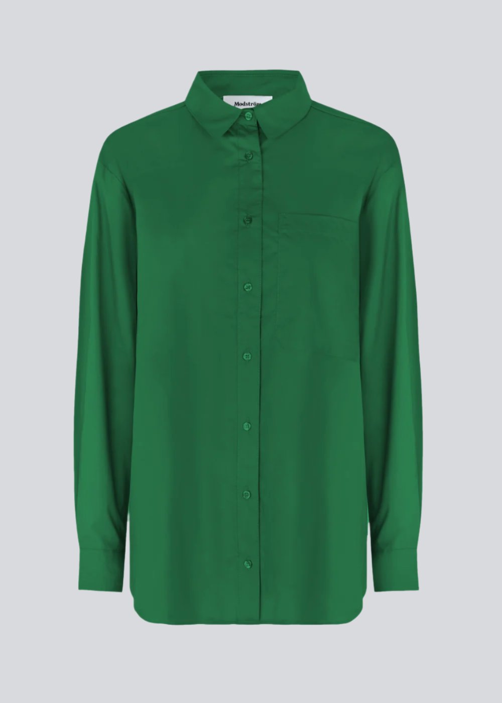 Airy shirt in green organic cotton poplin. TapirMD shirt has a collar and buttons in front, with an open chest pocket. Dropped shoulders and long sleeves with cuff and button. Embroidered logo in front.