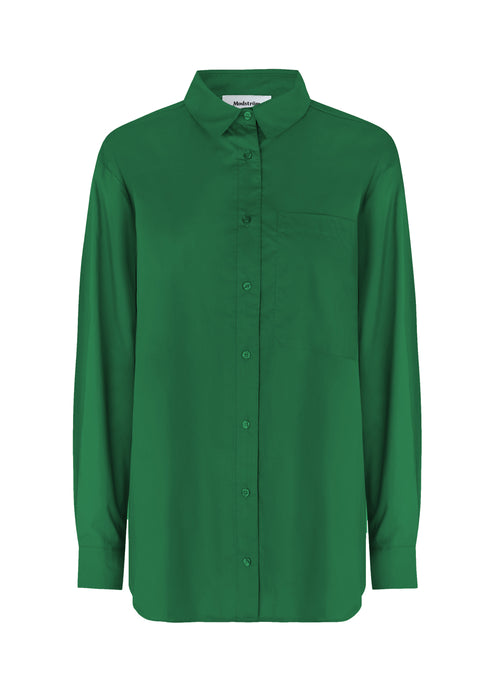 Airy shirt in green organic cotton poplin. TapirMD shirt has a collar and buttons in front, with an open chest pocket. Dropped shoulders and long sleeves with cuff and button. Embroidered logo in front.