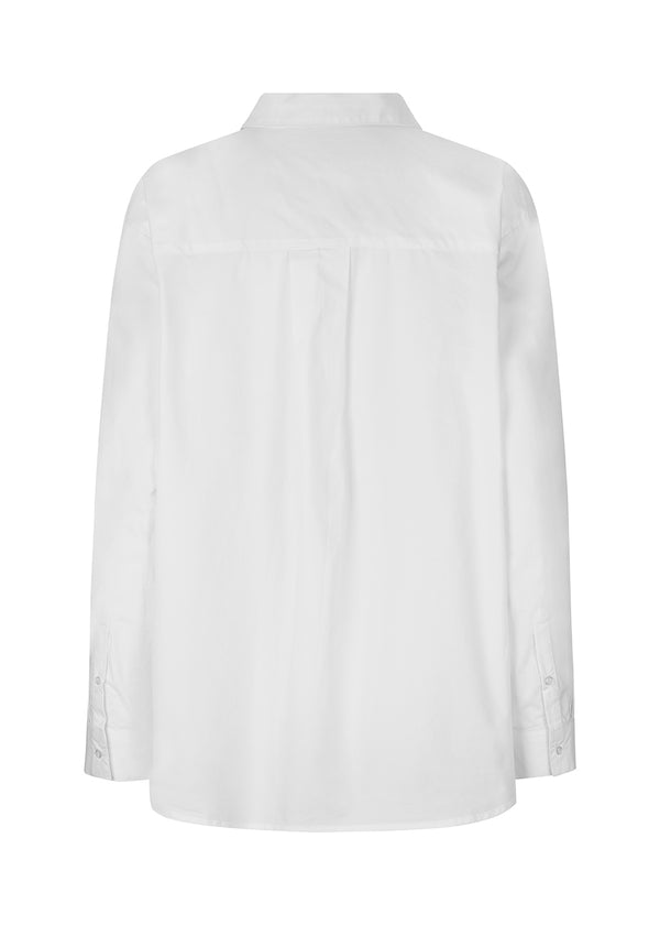Airy shirt in white in organic cotton poplin. TapirMD shirt has a collar and buttons in front, with an open chest pocket. Dropped shoulders and long sleeves with cuff and button. Embroidered logo in front.
