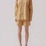 Shorts in a light, organic cotton poplin. TapirMD shorts have a high waist with elasticated waistband and short, wide legs. Pockets at side seam and a short slit at sides.  Material: 100% Organic Cotton