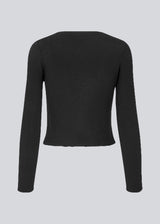Short cardigan in rib-knit with a feminine ruffled hem and long sleeves. TarikMD cardigan has a v-neckline and closure with ties in front.
