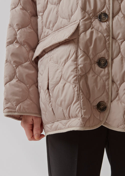 Padded jacket with a short voluminous silhouette. TinnyMD jackets has a collarless neckline, rounded slits, and two big pockets at front. Button closure.