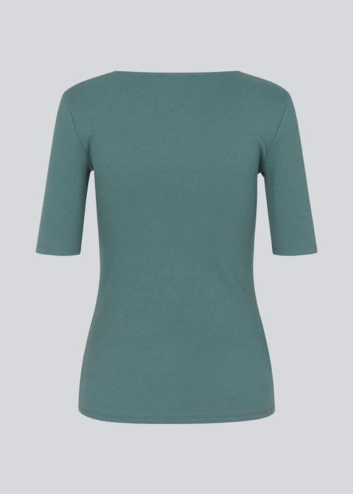Tight fit top in blue in a ribbed cotton jersey with a deep neckline in front and short sleeves cutting just above the elbow. 