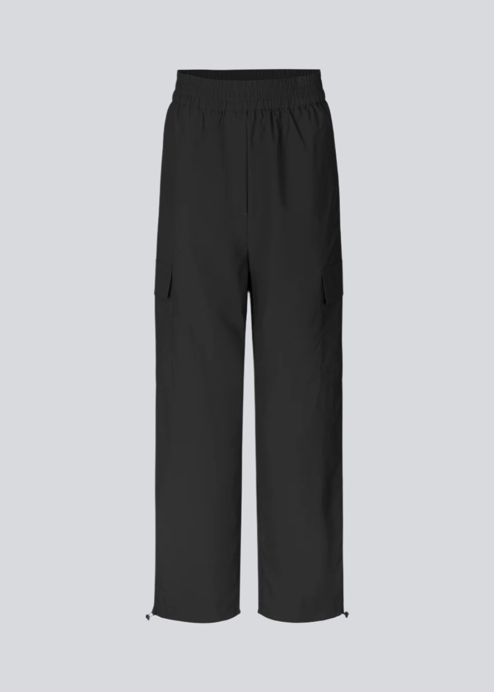 Cargo pants in nylon with elastic waistline and adjustable hems with elastic drawstrings. TrentMD pants have patch pockets on the legs. In black.  This is the same model as our popular pants AmayaMD pants. Just in a thicker material, perfect for fall and winter. 