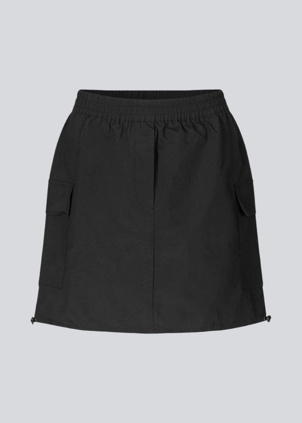 Short skirt in nylon with elastic waist and adjustable hems with elastic drawstrings. TrentMD skirt has two patch pockets and vertical cutlines on front and back.