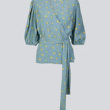 Floral top with a tie at the waist in blue with print. TuckerMD print top is a wrap shirt with short loose sleeves. The shirt is made of 100% responsible material.