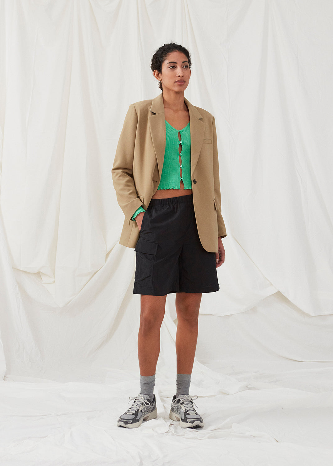 Slim fitted, slightly cropped cardigan in green with buttons at the front. DorisMD cardigan has a deep and round neckline, long sleeves, and lettuce hems. The model is 177 cm and wears a size S/36.