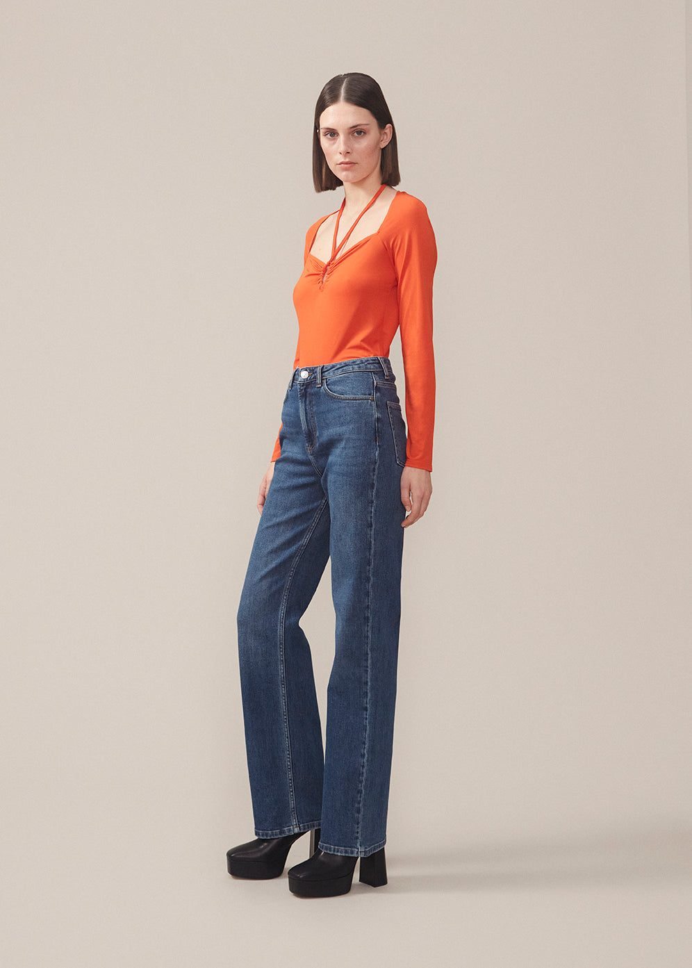 Long sleeved top in orange in a tight fit. BartoMD has a squared neckline with adjustable halterneck bow that can be tied at the neck.