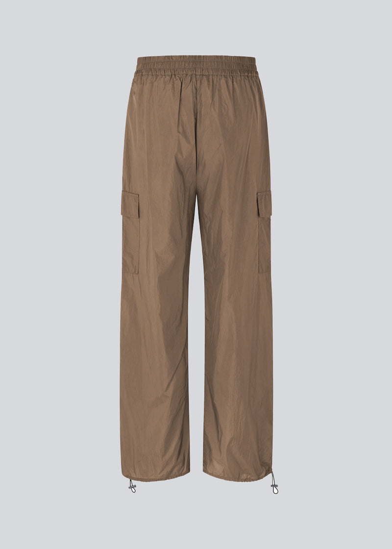 Pants in recycled nylon in the color Dune. AmayaMD pants have a high waist and straight legs with adjustable drawstring at hem. Covered elasticated waist and two large pockets on the legs.
