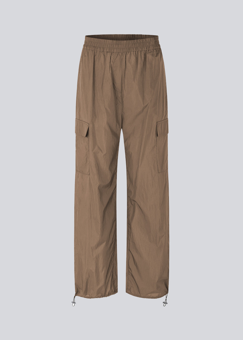 Pants in recycled nylon in the color Dune. AmayaMD pants have a high waist and straight legs with adjustable drawstring at hem. Covered elasticated waist and two large pockets on the legs.